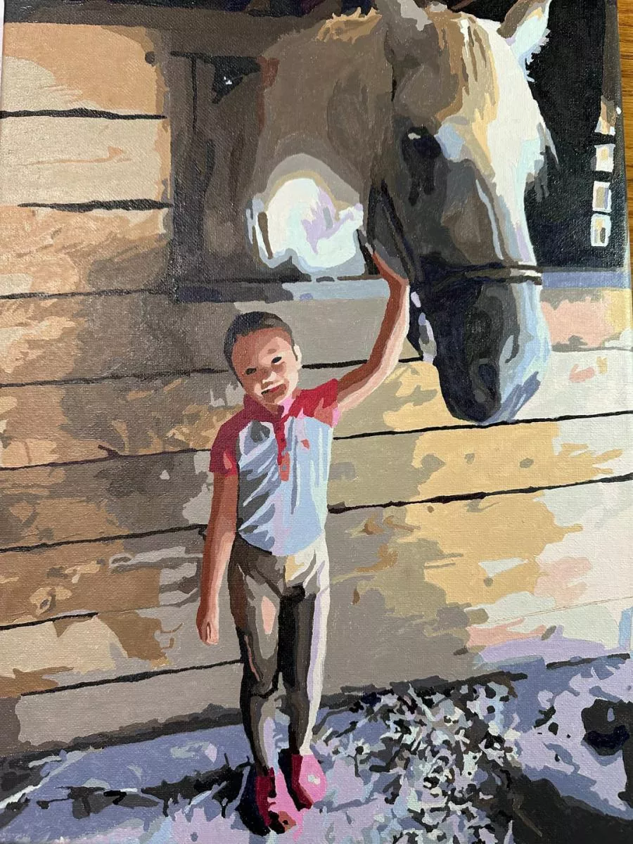 Child petting a horse in a custom paint by numbers portrait