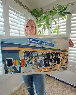 Customer holding a custom paint by numbers of a favorite local storefront