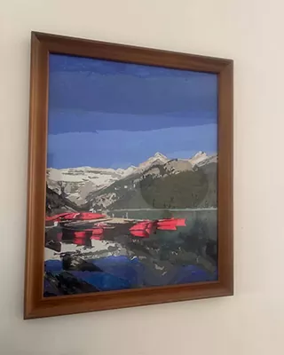 Framed custom landscape paint by numbers of a mountain lake with vivid red canoes beneath snow capped peaks