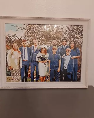 Framed custom paint by numbers family portrait displayed on a wall after completion
