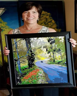 Framed custom paint by numbers landscape featuring a winding country road through the trees