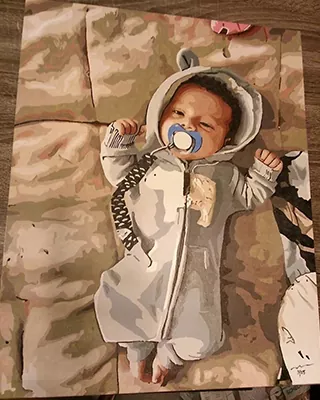 Baby in a cozy animal outfit featured in a custom paint by numbers portrait