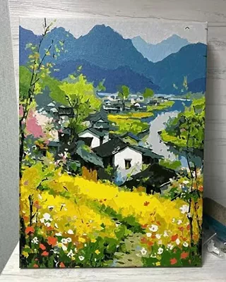 Bright countryside village surrounded by golden wildflowers and misty blue mountains