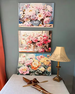 Collection of three completed floral paint by numbers canvases displayed on a wall