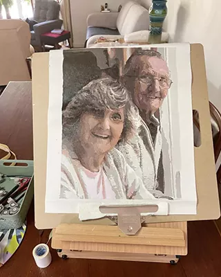 Completed paint by numbers canvas featuring a happy elderly couple
