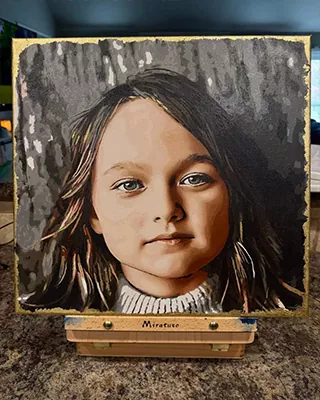 Custom child portrait of a young girl with long brown hair against a woodland backdrop
