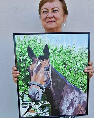 Custom horse portrait of a brown mule standing in lush green foliage