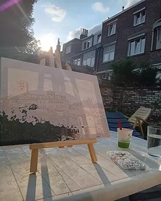 Custom paint by numbers cityscape in progress on an outdoor easel at sunset