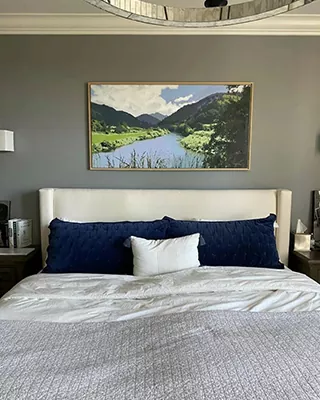 Custom paint by numbers landscape of a peaceful river valley displayed above a bed