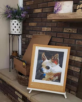 Custom paint by numbers portrait of a small white and brown dog displayed on an easel