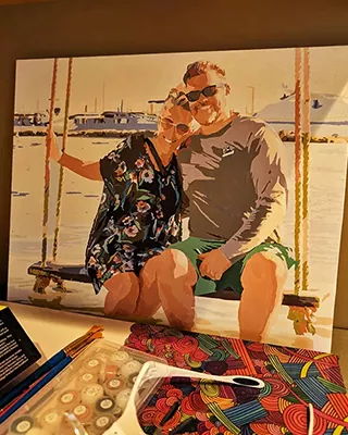 Custom paint by numbers portrait of a smiling couple relaxing together on a beach swing