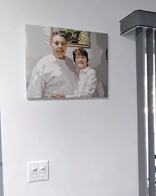 Custom paint by numbers portrait of an older couple displayed on a home wall