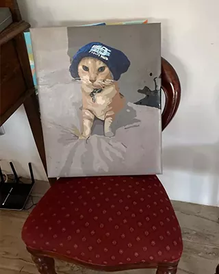 Custom paint by numbers portrait of an orange tabby cat wearing a blue knit hat