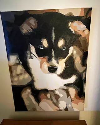 Custom pet portrait of a black and tan puppy with bright blue eyes
