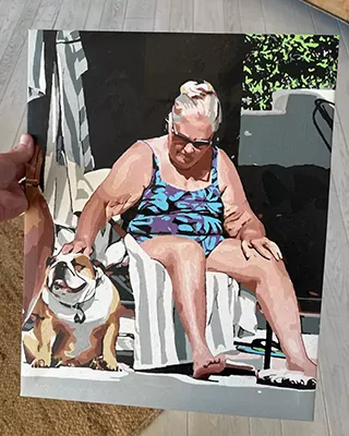 Custom portrait of a woman relaxing outdoors with her bulldog
