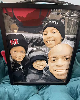 Family of four smiling together in a framed custom paint by numbers portrait