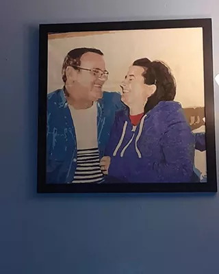 Framed custom paint by numbers artwork of a smiling couple looking at each other
