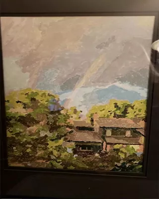 Framed custom paint by numbers landscape featuring a house surrounded by lush greenery and mountains