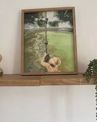 Framed custom paint by numbers of a child swinging over green water
