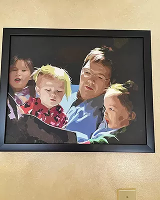 Framed custom paint by numbers portrait of a father reading with three children
