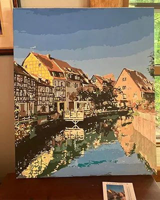 Historic riverside town reflected in the water in a custom paint by numbers landscape