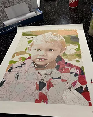 Partially completed custom paint by numbers portrait of a young child in a colorful jacket