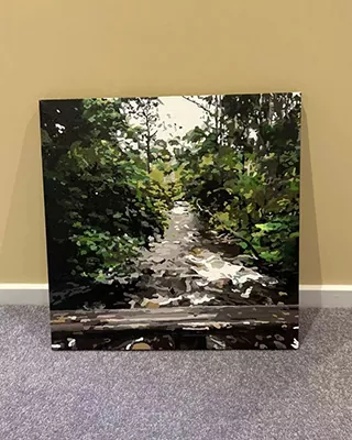 Shaded woodland path surrounded by dense green trees in a custom paint by numbers landscape