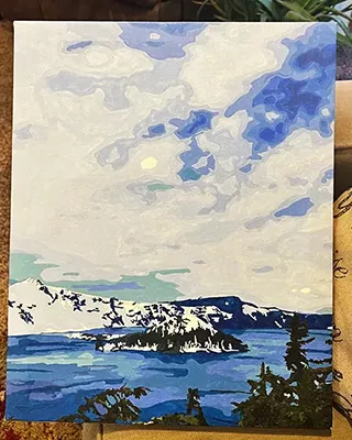 Snowy mountains and pine-covered islands reflected in a blue lake in a personalized paint by numbers landscape
