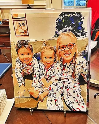 Three smiling family members in matching pajamas featured in a custom paint by numbers portrait