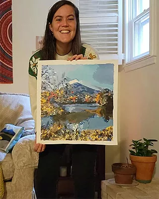 Woman proudly holding her personalized paint by numbers mountain landscape