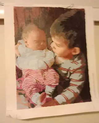Young child holding a sleeping baby in a custom paint by numbers portrait